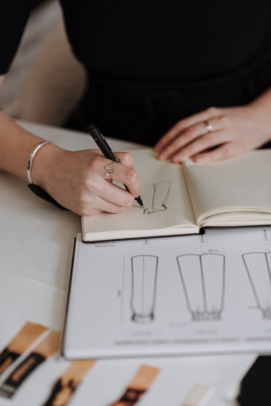 Designer refining a garment sketch at the studio table