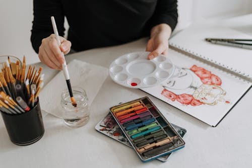 Free Crop artist painting at table Stock Photo