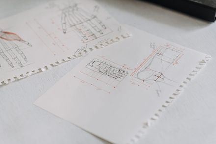 Technical drawings laid out across white sheets — photo by Anete Lusina on Pexels