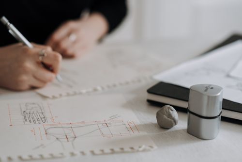 Free Detailed hand sketching on architectural blueprints with drawing tools and notebook. Stock Photo