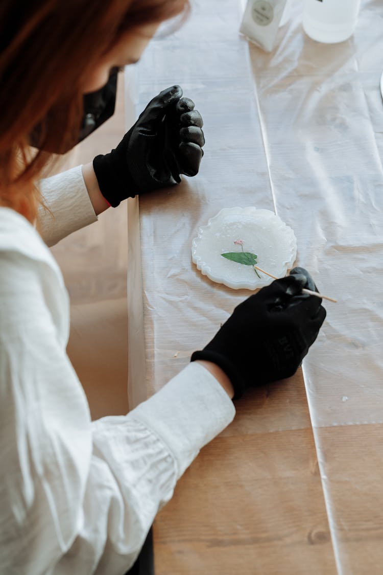 Woman Sitting And Decorating Plate