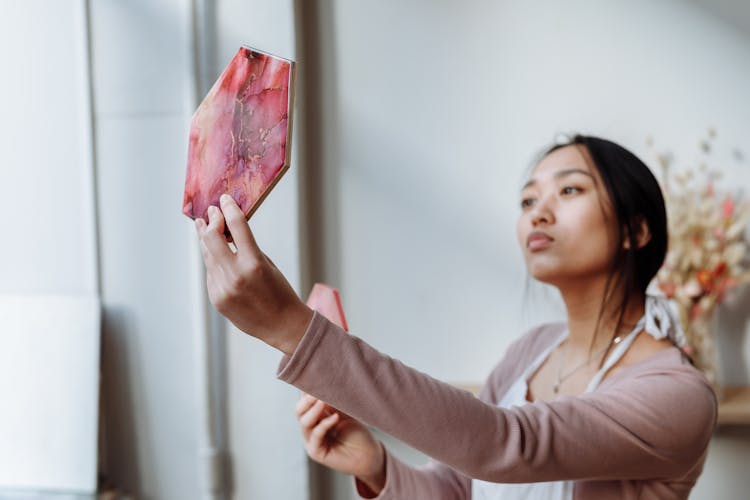 A Woman In Beige Long Sleeves Looking At The Resin Art With Hexagon Shape