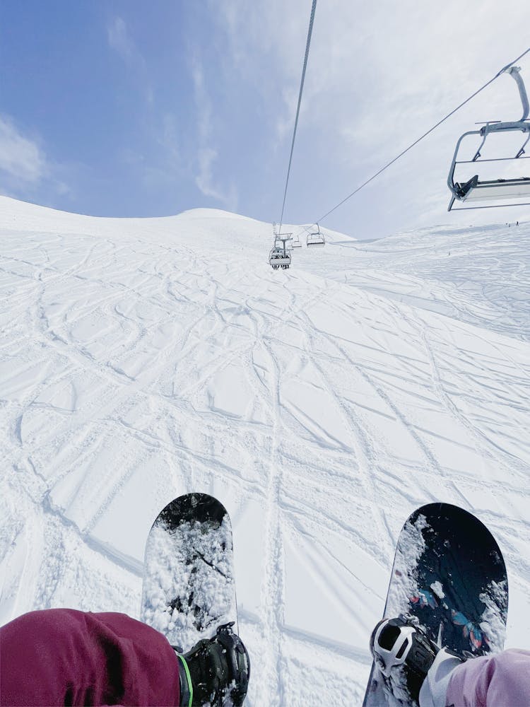 Snowboarders Riding A Ski Lift