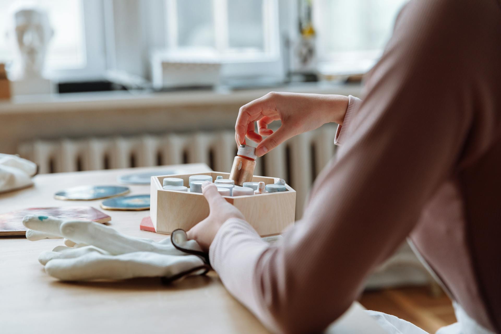 A Person Taking a Bottle from a Wooden Container