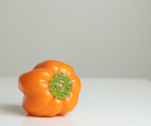 Photo of an Orange Bell Pepper on a White Surface
