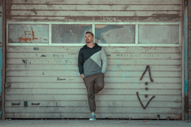 Confident Man Leaning On Weathered Wall