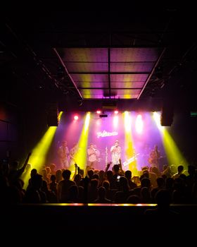 Vibrant live performance at a Buenos Aires nightclub showcasing musicians under electric lights.