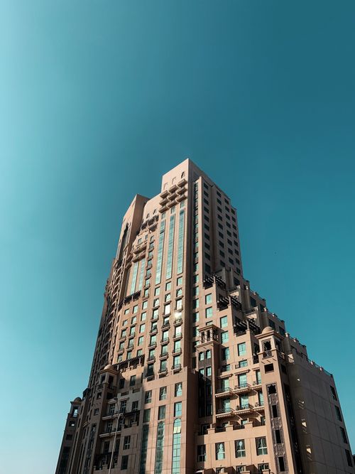 Free A towering modern skyscraper in Dubai against a bright blue sky, showcasing urban architecture. Stock Photo