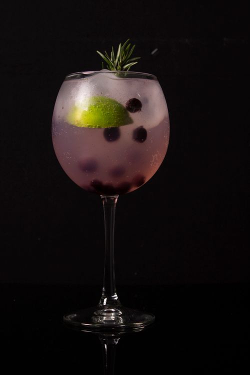 Free A refreshing cocktail with lime and berries in a clear glass against a black background. Stock Photo