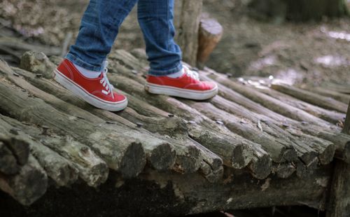 Free Close-up of red sneakers walking on a wooden bridge in Eberswalde forest. Stock Photo