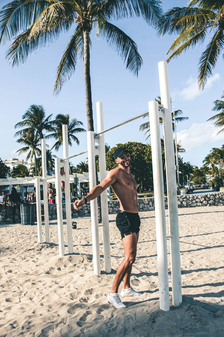 Shirtless Man Standing Under The Monkey Bar