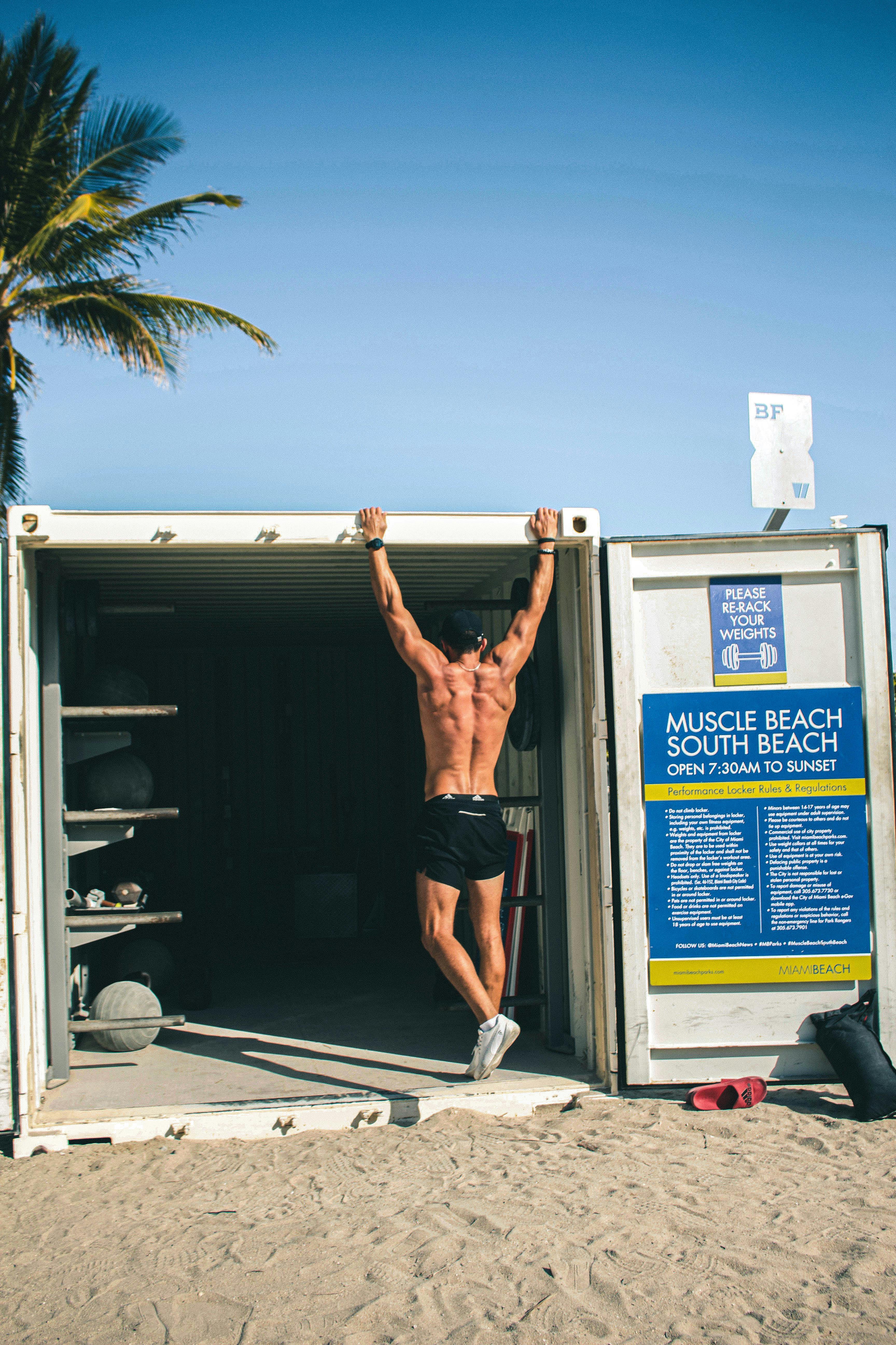 man standing in a freight container flexing his muscles