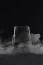Inverted glass with steam in black studio