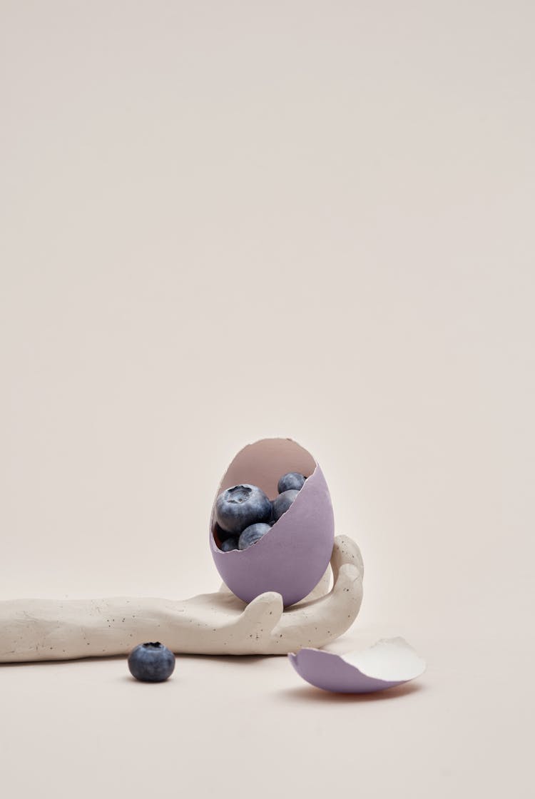 Purple Eggshell With Blueberries On Clay Hand