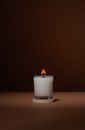Burning candle on table in studio
