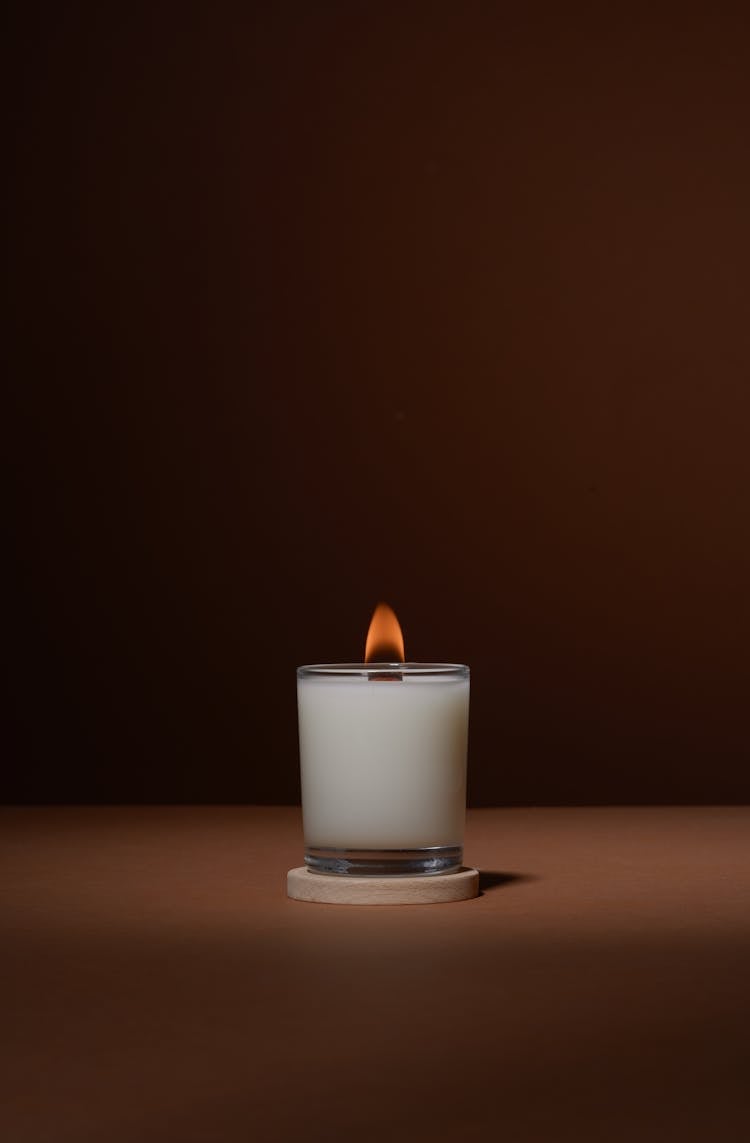 Burning Candle On Table In Studio