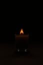 Flaming candle in dark obscure studio