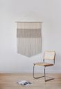 Decorative element hanging on wall in room with minimalist design