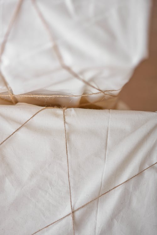 High angle of boxes covered with crumpled fabric and tied with thin thread
