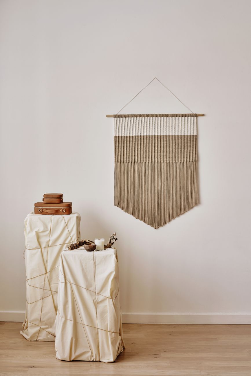A tall woven wall hanging with clear breathing room, showing how vertical pieces change the pull of a plain wall.