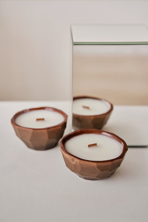 Free Wax candles in geometric holders near mirror Stock Photo