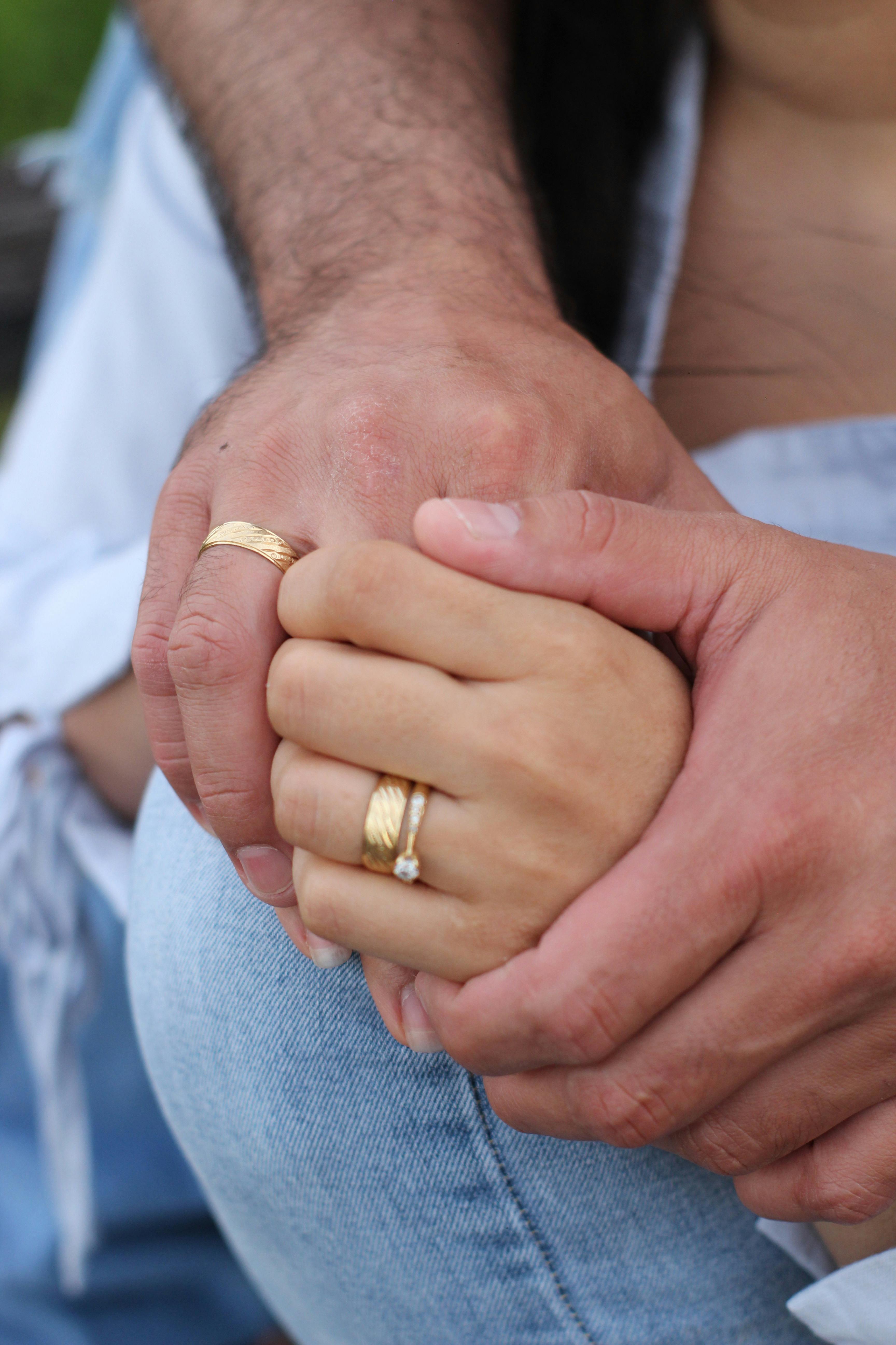 Free Close-up of a couple's hands with wedding and engagement rings, symbolizing love and commitment. Stock Photo