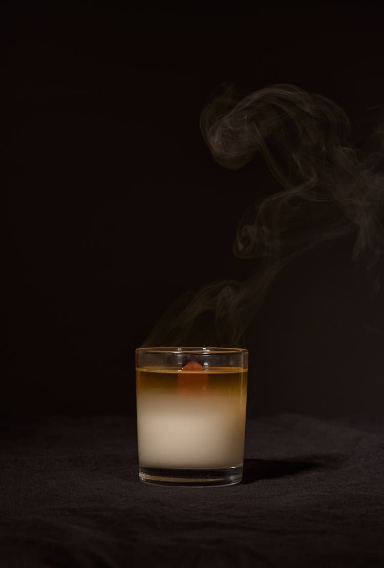 Extinguished Candle In Glass Holder In Dark Studio