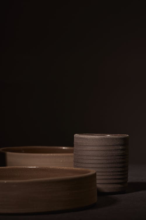Free Round ceramic dishes placed on black surface Stock Photo