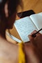 Person Writing on Notebook
