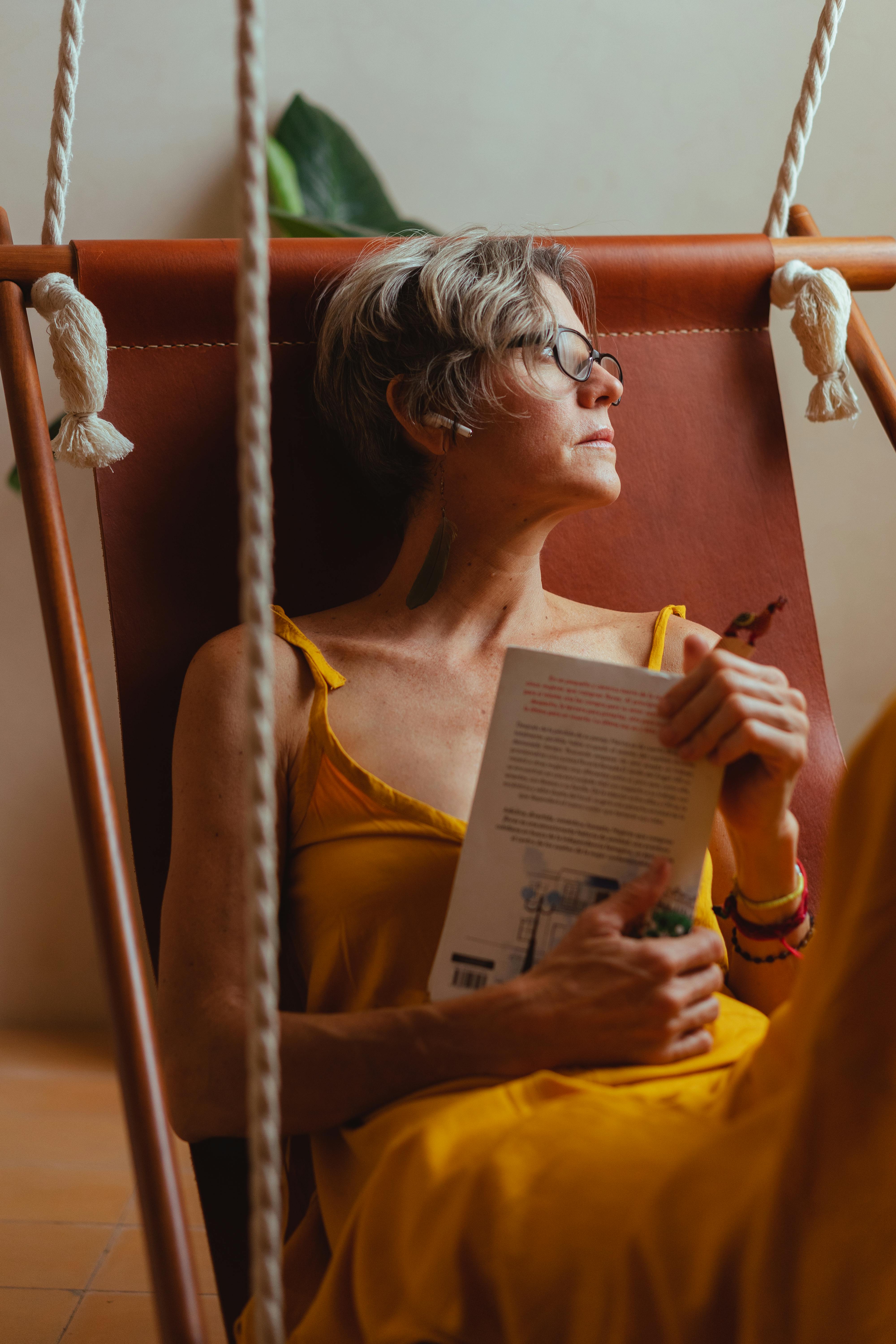 elderly woman looking pensive while holding a book