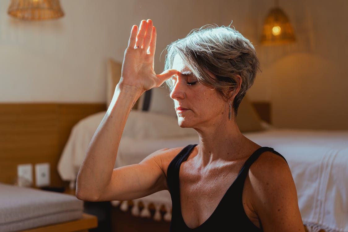 Exercise for Parkinson's Disease Free Serene elderly woman practicing yoga meditation indoors, symbolizing wellness and positive aging. Stock Photo