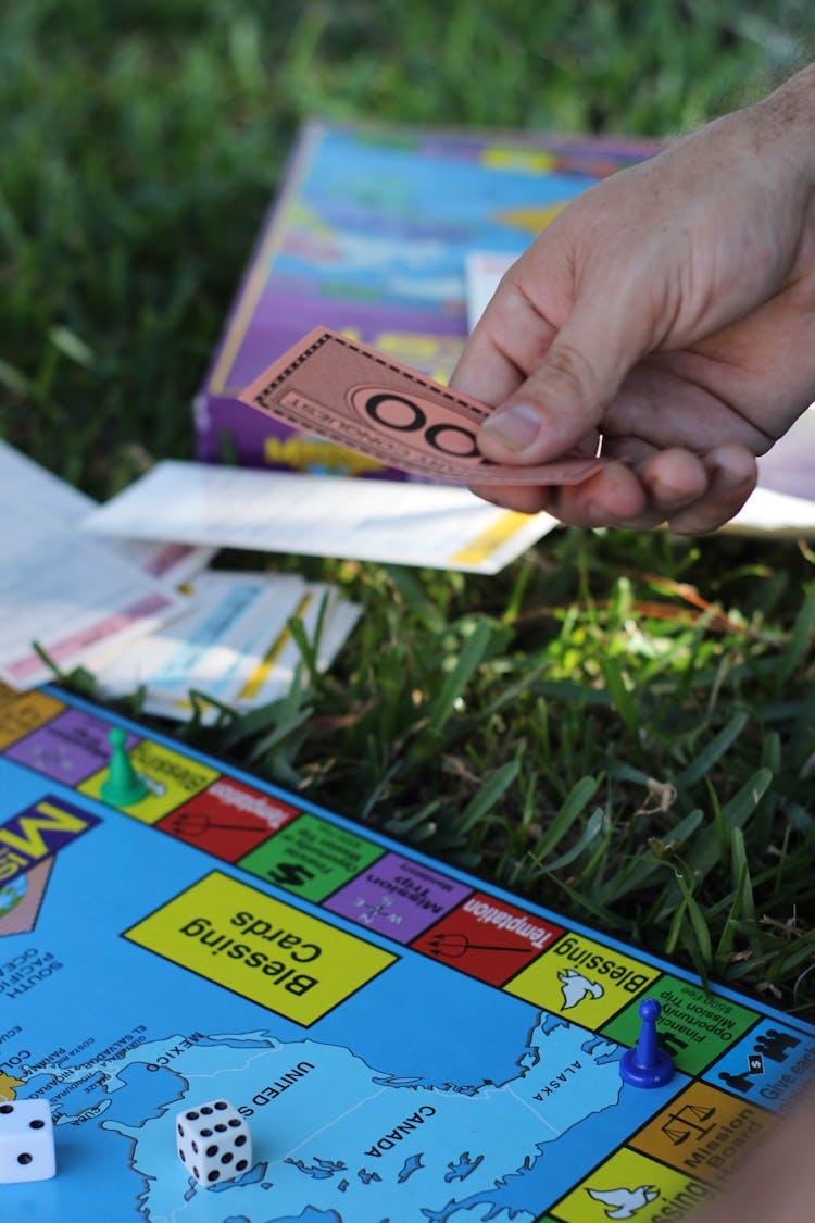 Person A Playing Monopoly Holding A Play Money