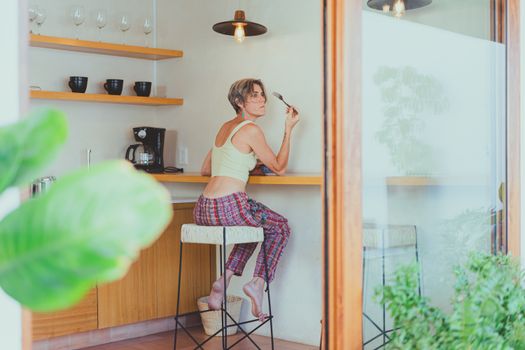 A senior woman enjoying a healthy breakfast indoors, promoting a positive aging lifestyle.