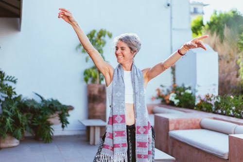 Free Woman Laughing while Raising Her Both Arms Stock Photo