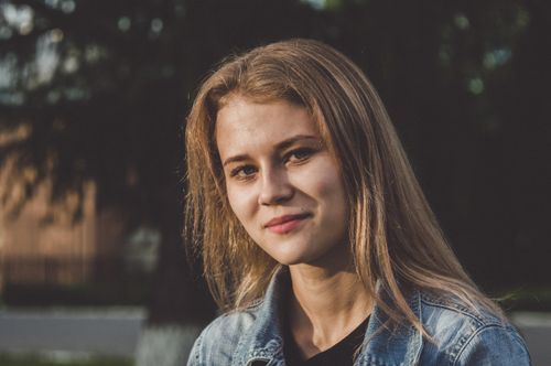 Free Smiling young woman in casual attire enjoying a sunny day in the park. Stock Photo