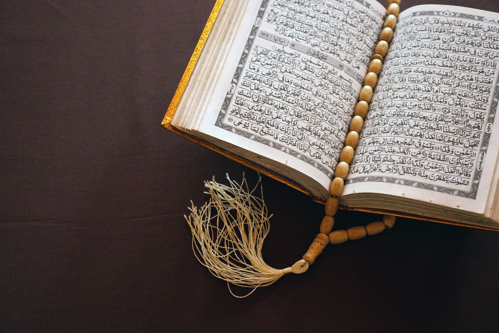 Alcorão aberto com tasbih sobre as páginas