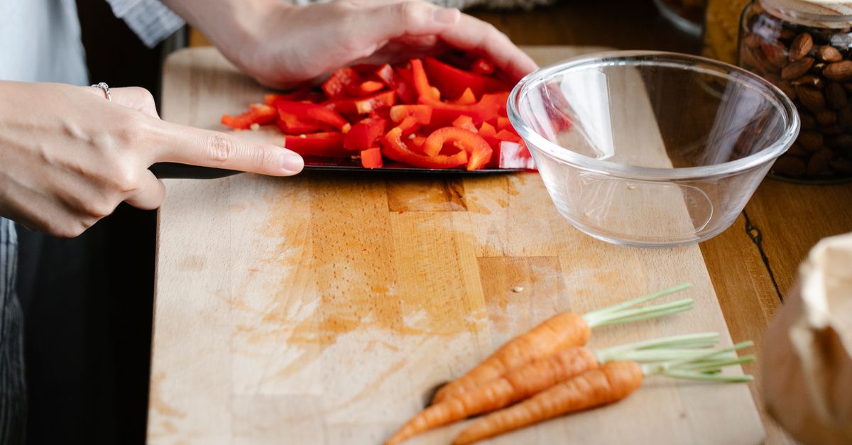A beautifully organized kitchen counter with fresh vegetables, cutting boards, and meal prep containers, warm lighting