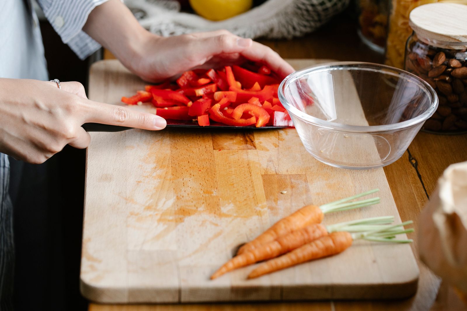 Poivron rouge émincé et carottes sur une planche, mise en place des légumes pour les nouilles sautées