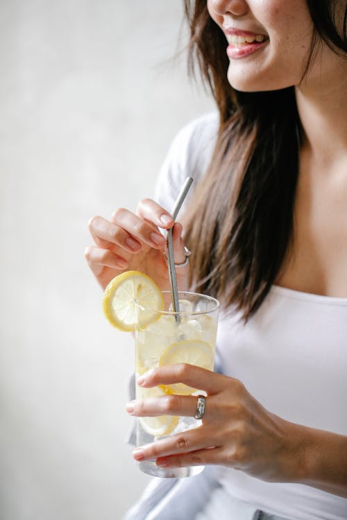 Smiling crop woman with refreshing lemonade