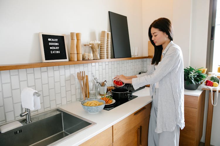 Asian Woman Cooking Near Stove