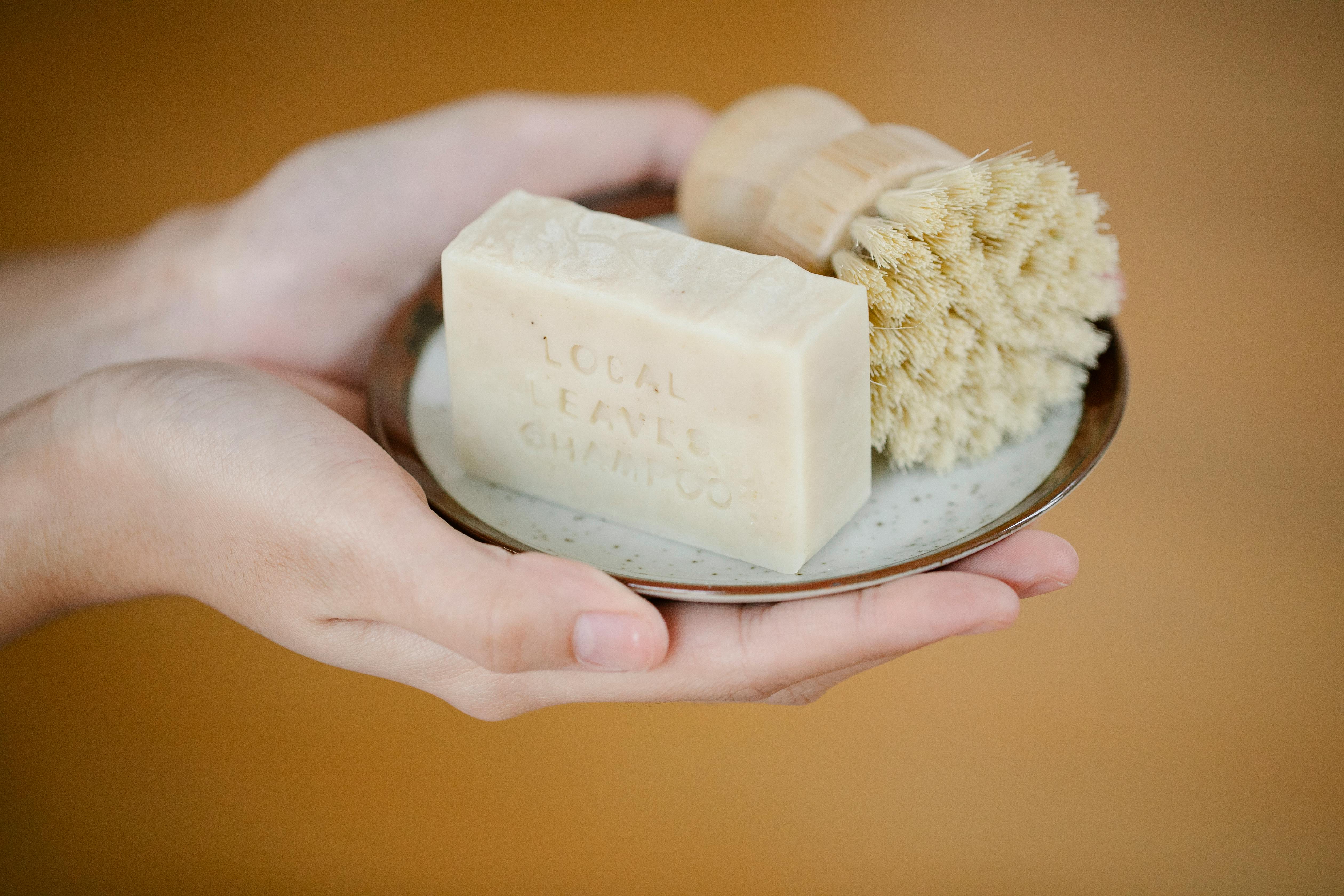 Crop person with soap in brush