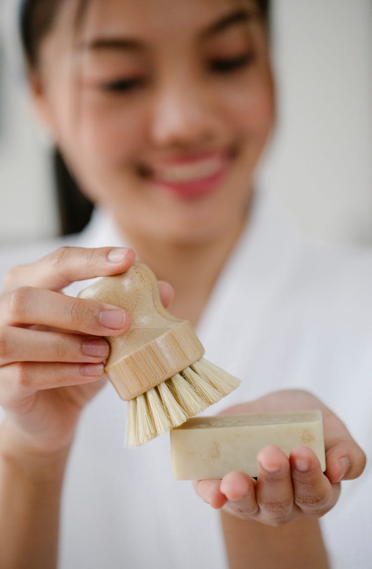 Crop Smiling Asian Woman With Natural Brush And Soap Block