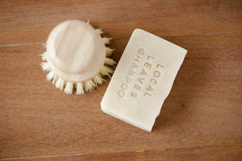 Top view of zero waste beauty brush and dry shampoo with inscription on brown background