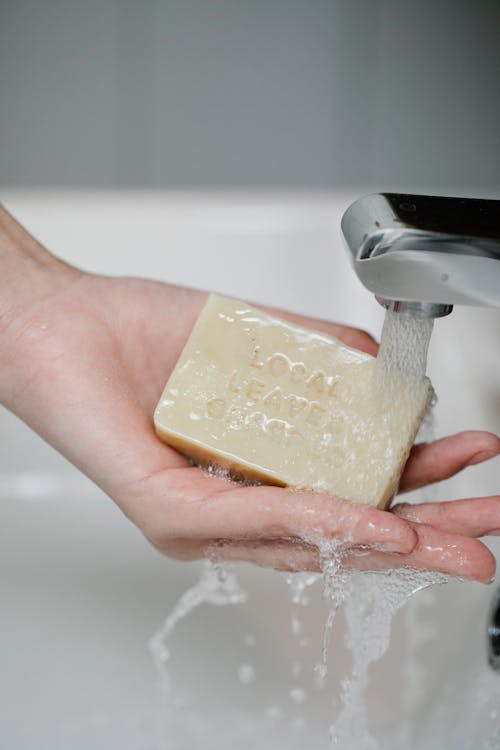 Crop person washing hand with soap