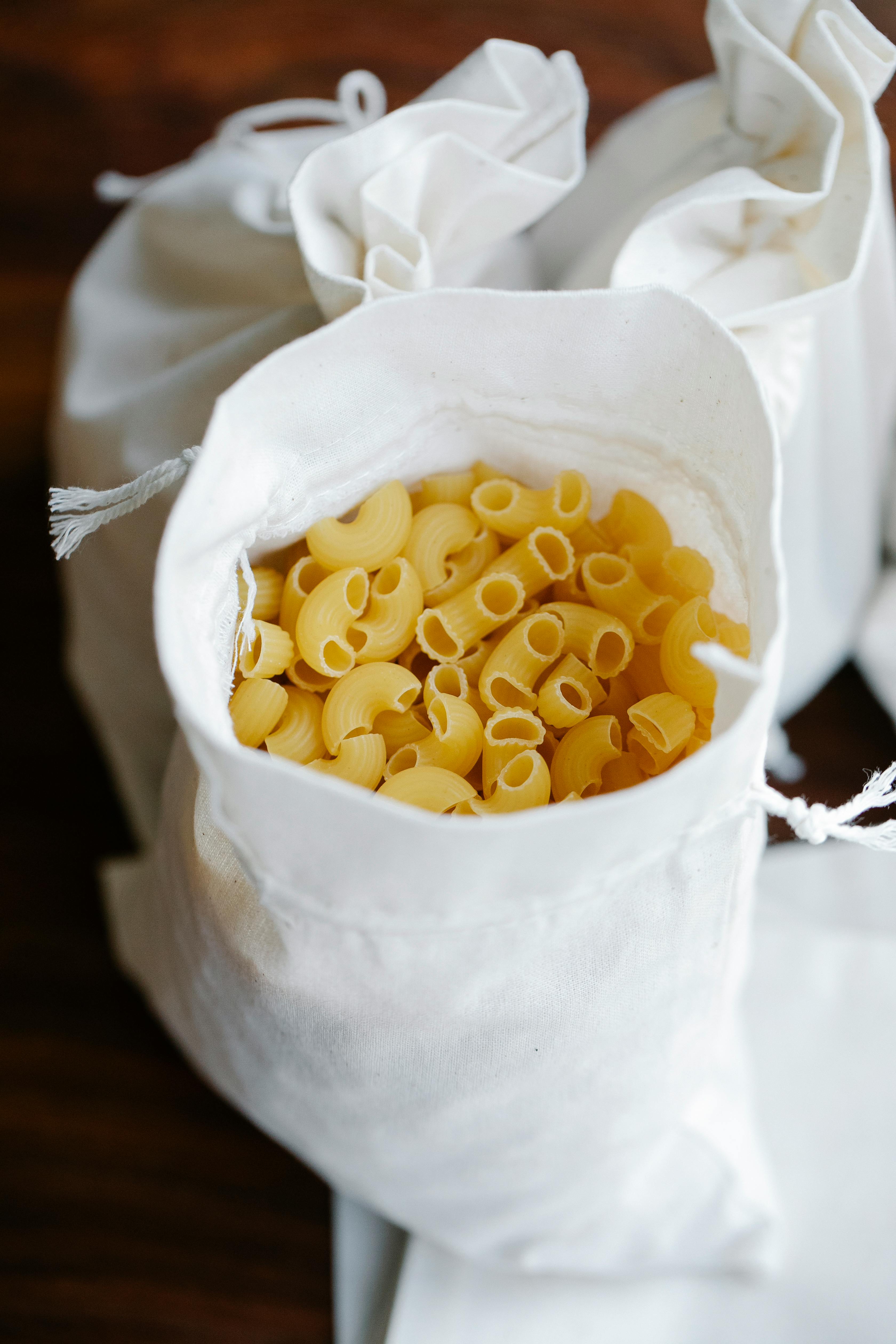 sacks with raw pasta in kitchen