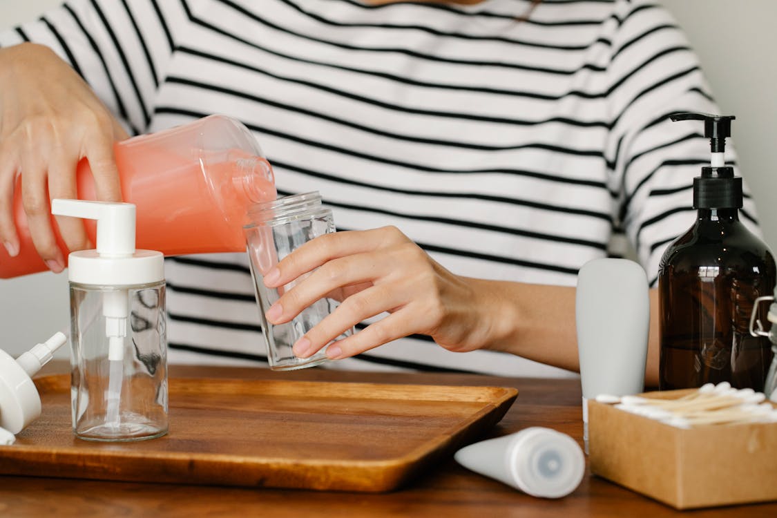 Free Anonymous person pouring soap from dispernser Stock Photo