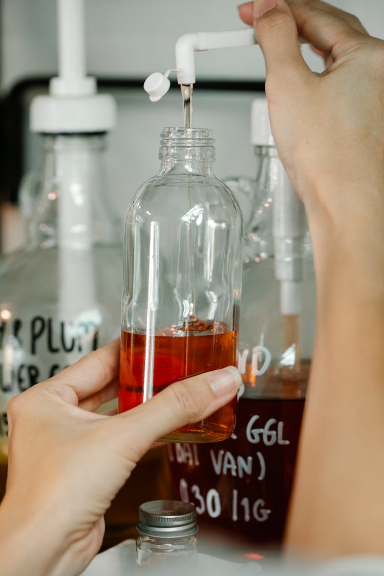 Anonymous Person Pushing And Pouring Shampoo Into Bottle