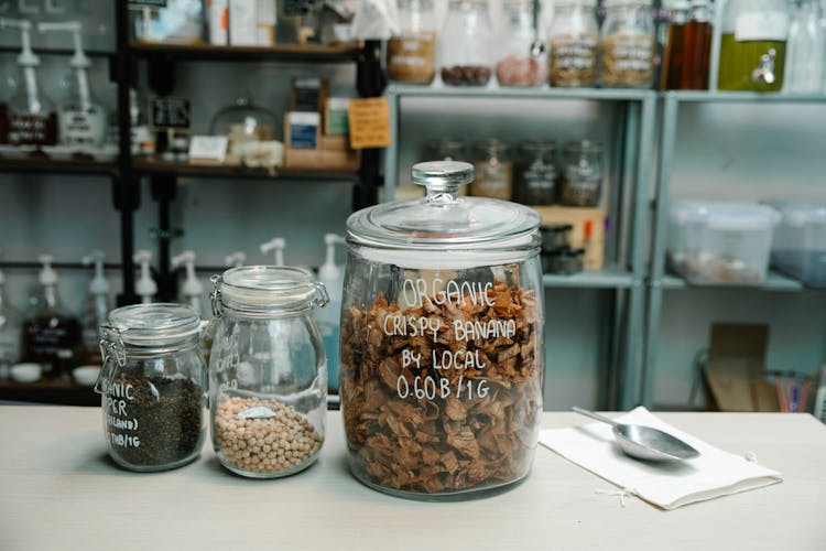 Jars Of Dried Fruits, Herbs And Spices On A Countertop