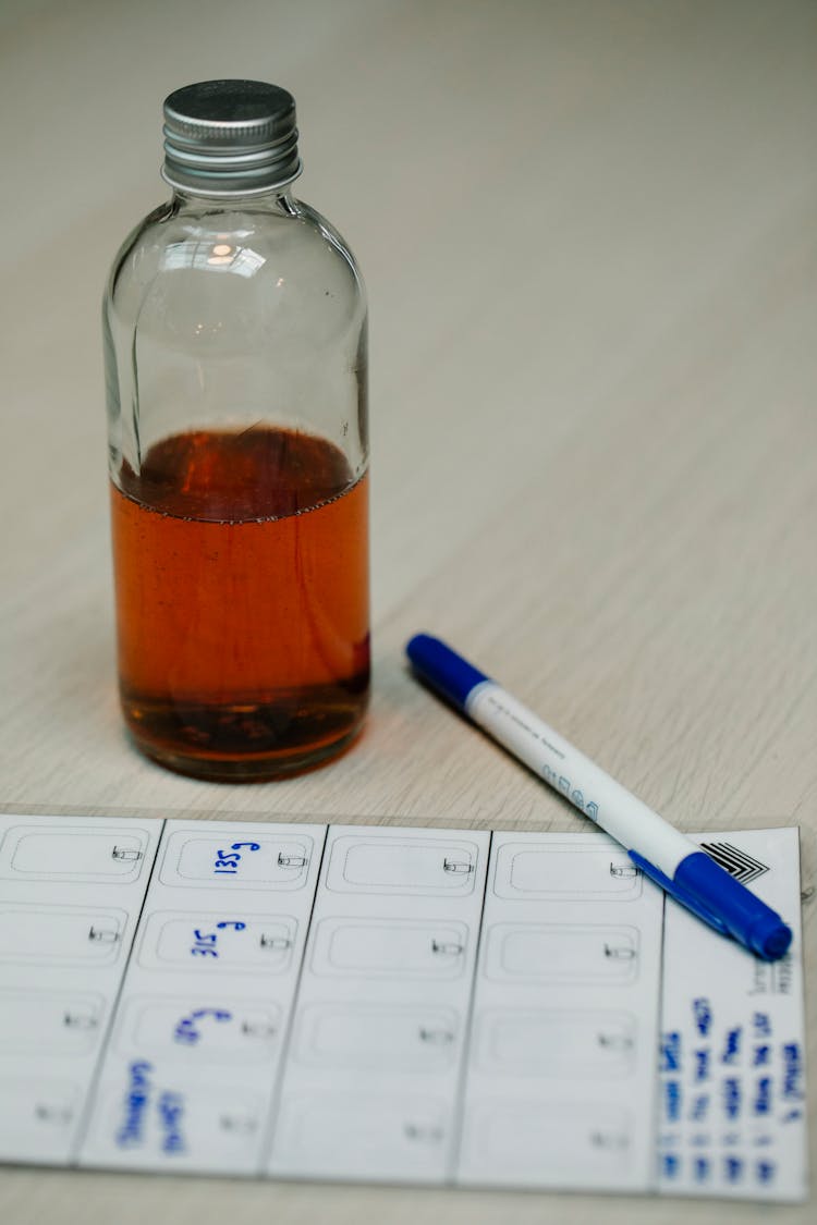 Glass Bottle With Lab Specimen On Table