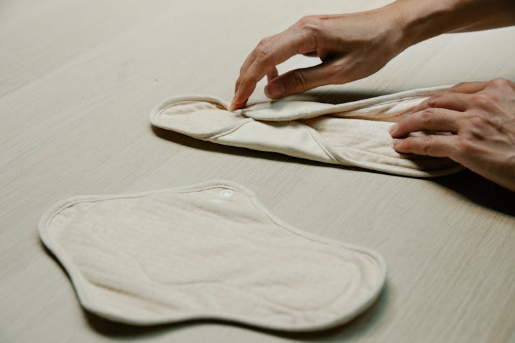 A Person Folding A Reusable Sanitary Pad